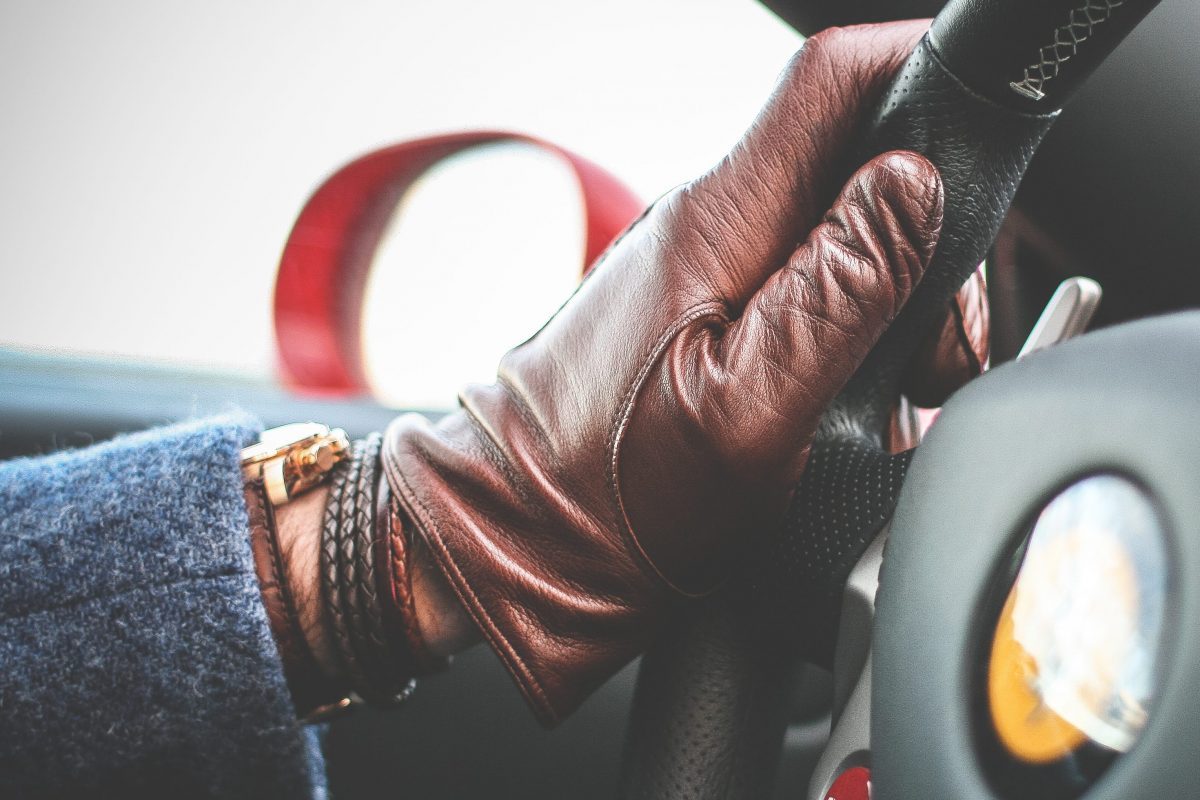 man driving car with driving glove