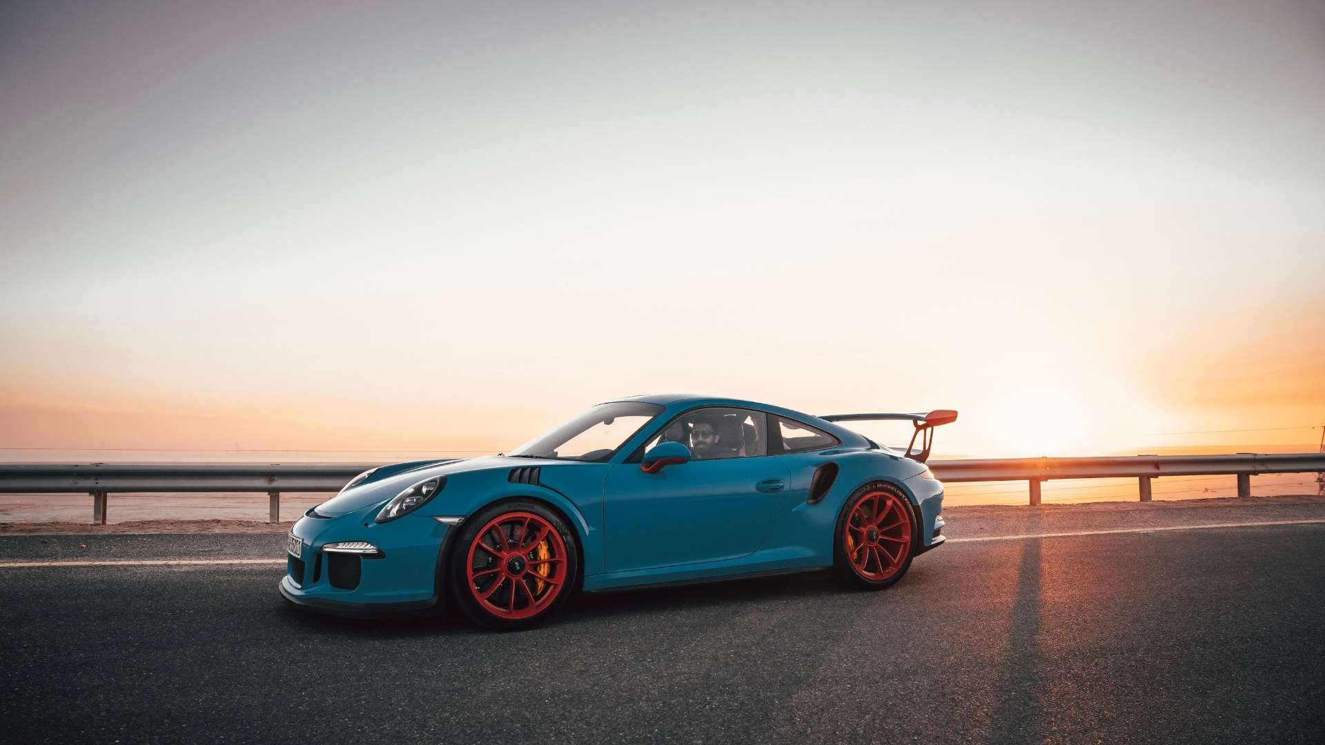 blue Porsche with red wheels